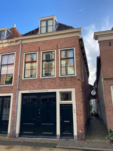 um edifício de tijolos com portas e janelas pretas em Monumental house, apartment in Center Haarlem em Haarlem