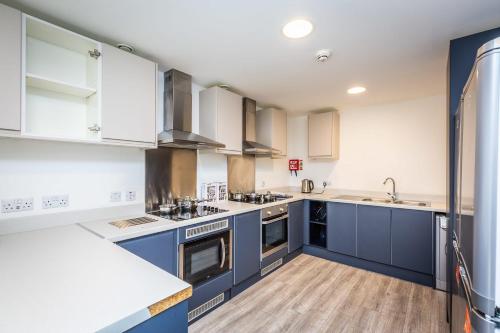 a kitchen with blue cabinets and white counters at Ensuite Room With Shared Kitchen, Close to Centre- 18 above in Lincoln