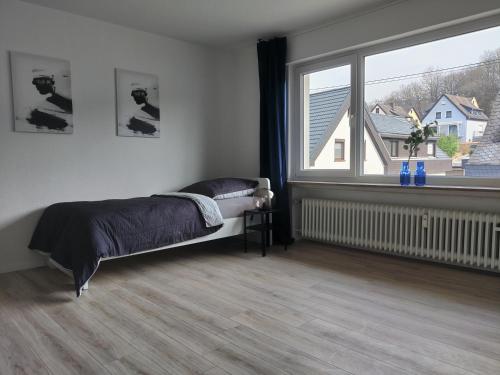 1 dormitorio con cama y ventana grande en DWK: Monteurhaus bei Neuwied en Niederbreitbach