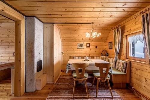 a dining room with a table and chairs in a cabin at Jagdhütte Gammeringalm in Spital am Pyhrn