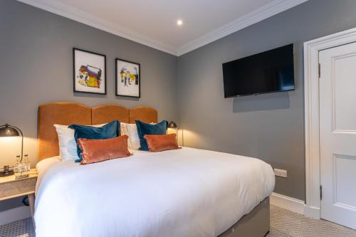 a bedroom with a large bed with a flat screen tv at The Scott in Edinburgh