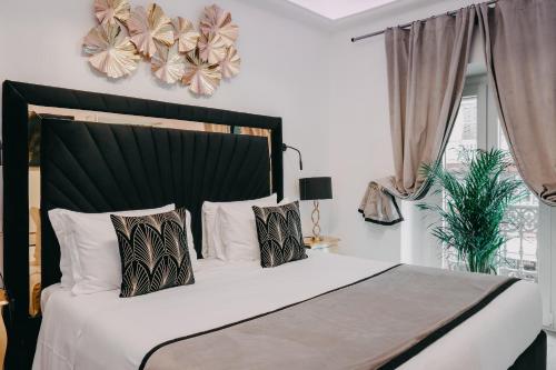 een slaapkamer met een groot bed met witte lakens en kussens bij Imperial Rhome Guest House in Rome