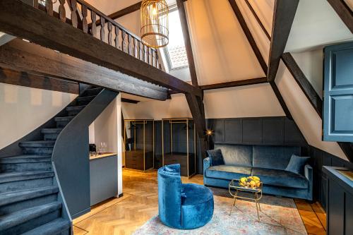 ein Wohnzimmer mit einem blauen Sofa und einer Treppe in der Unterkunft CTY Books in Leiden