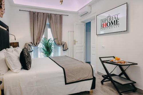 um quarto com uma grande cama branca e uma mesa em Imperial Rhome Guest House em Roma