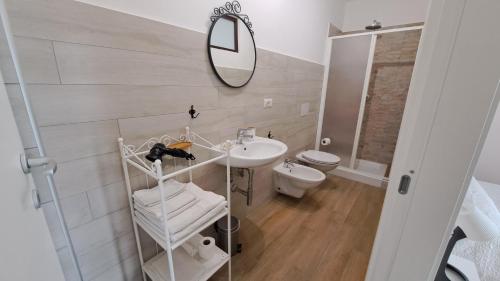 La salle de bains est pourvue d'un lavabo, de toilettes et d'un miroir. dans l'établissement Altomuro 39 di S.A., à Formia