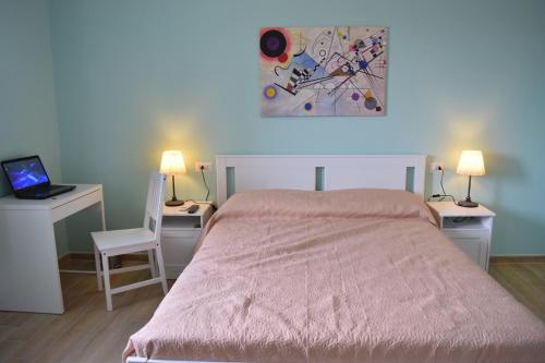 - une chambre avec un lit, deux bureaux et un ordinateur portable dans l'établissement Altomuro 39 di S.A., à Formia