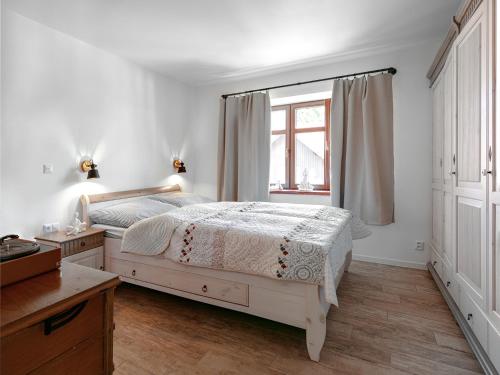 Un dormitorio blanco con una cama y una ventana. en U líného jezevce, en Abertamy