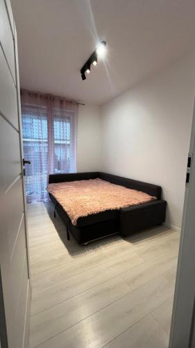een slaapkamer met een bed in de hoek van een kamer bij Nowe mieszkanie 4-osobowe z ogródkiem Kraków in Krakau