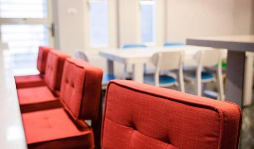 a row of red chairs in a room with a table at Lanven Art House in Hualien City