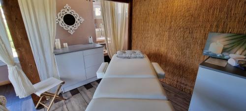 a room with two white tables and a mirror at Logis Hôtels Le Saint Marc in Mollans-sur-Ouvèze