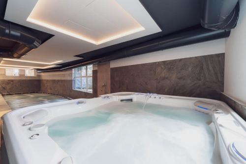 a large bath tub in a room at Hotel Diamant Park in Campitello di Fassa