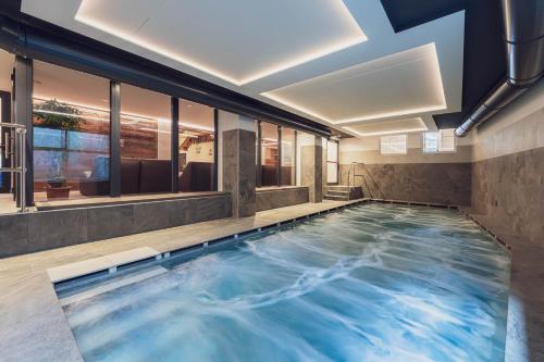 una grande piscina in un edificio con soffitto di Hotel Diamant Park a Campitello di Fassa