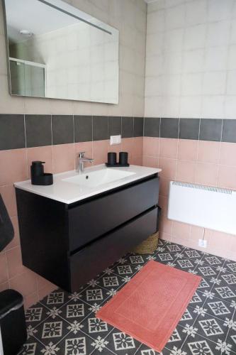 a bathroom with a sink and a mirror and a tub at Bed & Breakfast De Bodderie in Nieuwland