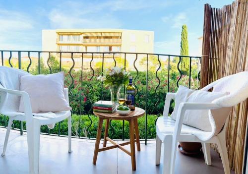 un balcón con 2 sillas y una mesa con un jarrón de flores en private room with balcony, en Saint-Tropez