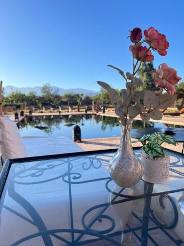 a vase with roses in it sitting on a table at Kasbah Caracalla in Aghmat