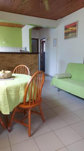 ein Esszimmer mit einem Tisch, Stühlen und einem Sofa in der Unterkunft Studio La villa du manguier in Le Vauclin