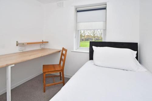 a bedroom with a bed and a desk and a chair at Sweetbriar House - By Sigma Stays in Crewe