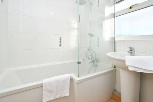 a white bathroom with a sink and a glass shower at Sweetbriar House - By Sigma Stays in Crewe