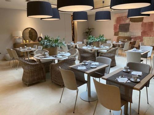 a dining room with tables and chairs and lights at Zenit Valencia in Valencia