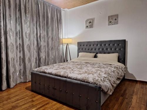 een slaapkamer met een groot bed met een grijs hoofdeinde bij Danais in Athene