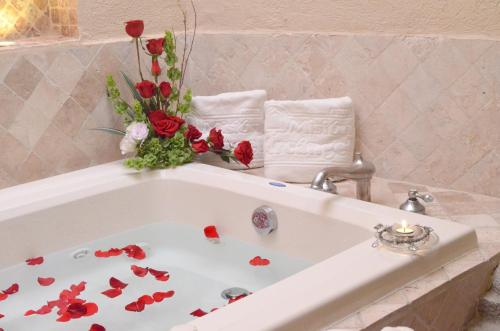 a white bath tub with red roses in a bathroom at Arcángel Puebla in Puebla