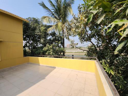 a balcony of a house with a yellow wall at Aaira Manjil Guest House in Dhaka