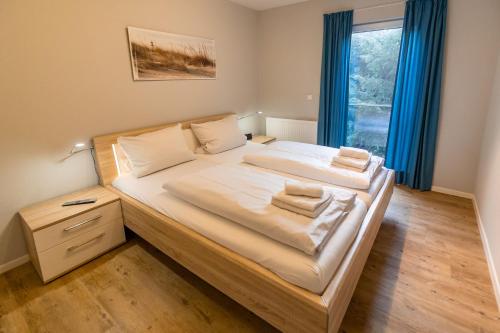 1 dormitorio con 1 cama grande y cortinas azules en Dieknüst, en Greetsiel
