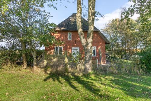 a red brick house with trees in front of it at Andrea in Aventoft