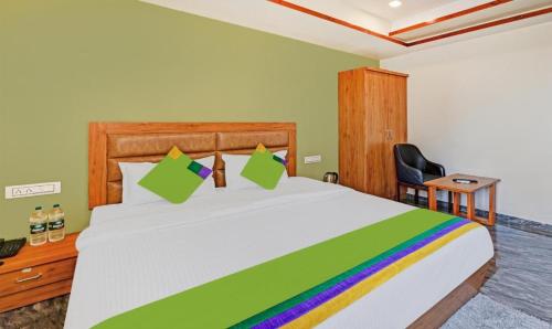 1 dormitorio con 1 cama blanca grande con colcha de arco iris en Hotel Shree Regency, Ahmedabad, en Ahmedabad