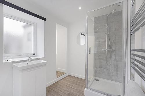 a white bathroom with a shower and a sink at Cozy Home in Avenue Terrace, Sleeps 8 in Sunderland