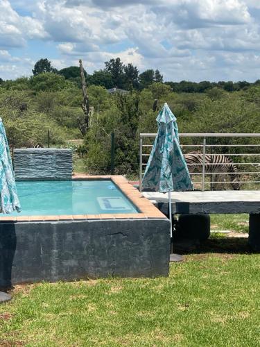 a small swimming pool with a table and a fence at Kings view exclusive villas (KVEV) in Pretoria-Noord