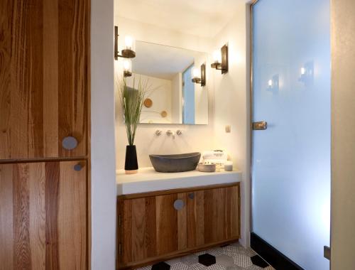 a bathroom with a sink and a mirror at Yellow Orchid Cycladic House in Pirgos