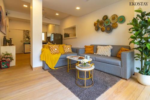 a living room with a blue couch and a table at EKOSTAY Luxe - Casa Marina in Candolim