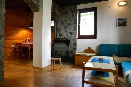 a living room with a blue couch and a fireplace at Planinska kuća Savić, Kopaonik in Kopaonik