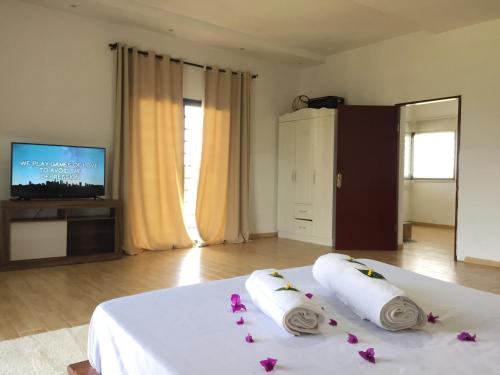 a bedroom with a white bed with flowers on it at Sanda GuestHouse in Antsirabe