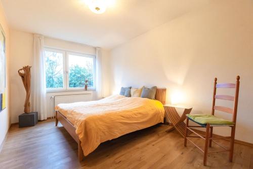 a bedroom with a bed and a chair and a window at Ferienwohnung Familie Weihe in Reppenstedt