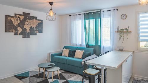 un salon avec un canapé bleu et une table dans l'établissement Zadig - Proche Hypercentre - 4 pers., à Troyes