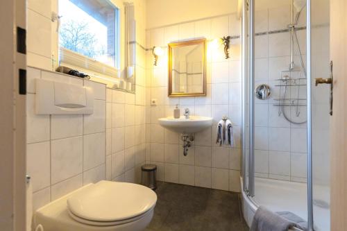 a bathroom with a toilet and a sink and a shower at Ferienwohnung Familie Weihe in Reppenstedt