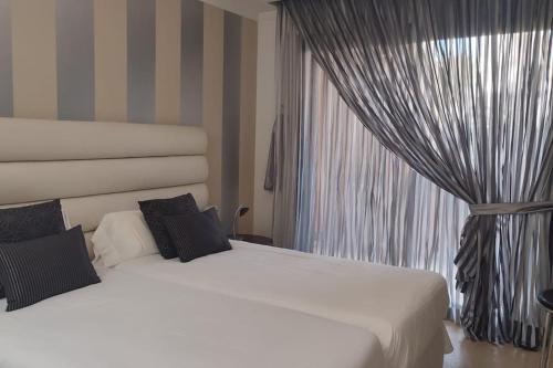 EsteponaLos Granados del Mar Estepona的有两张床和一扇窗户的卧室