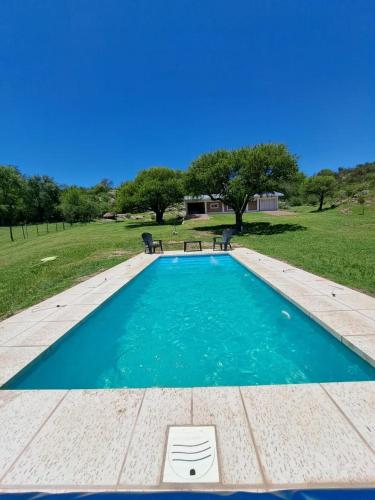 - une piscine d'eau bleue dans un champ dans l'établissement LOS CALDENES, à Trapiche