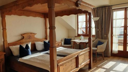 a bedroom with a four poster bed and a table at Weingut Magdalenenhof in Rüdesheim am Rhein