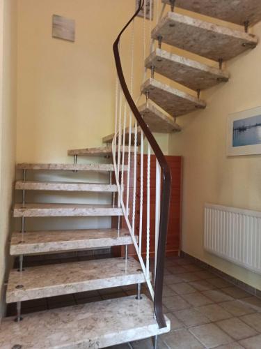 a staircase in a house with a wooden railing at Ferienhaus Friesenrose 45237 in Ditzum