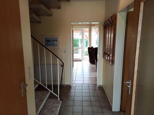 a hallway with a staircase leading to a door at Ferienhaus Friesenrose 45237 in Ditzum