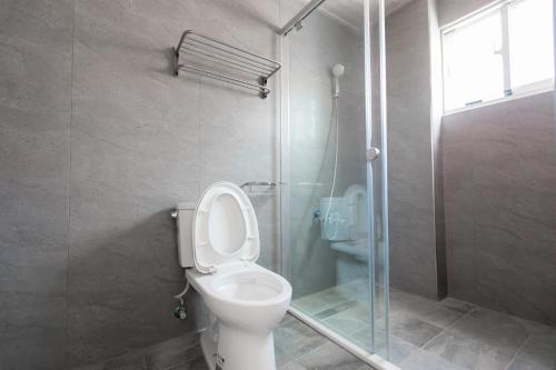 a bathroom with a toilet and a glass shower at snoozinn in Huxi