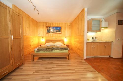 una camera con letto e parete in legno di Apartma Felix a Kranjska Gora