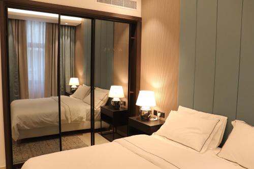 a hotel room with two beds and a mirror at Liyaqat Airport Residence in Muscat