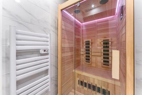 une douche avec une porte vitrée dans une salle de bain dans l'établissement Le Rex - Bel appt avec sauna, à Nantes