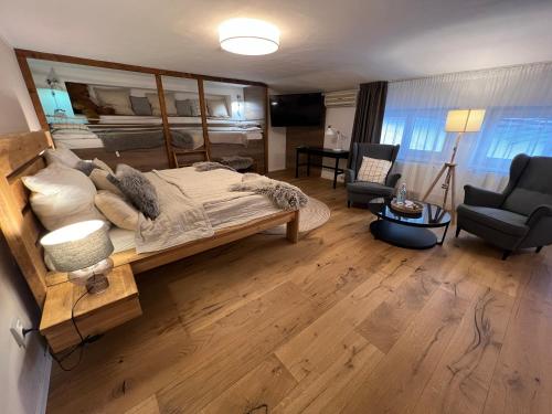 a bedroom with a large bed and a living room at Hotel McLimon in Nový Jičín