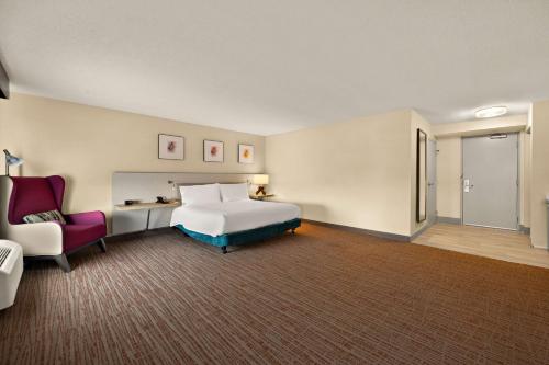 a hotel room with a bed and a chair at Hilton Garden Inn Williamsburg in Williamsburg