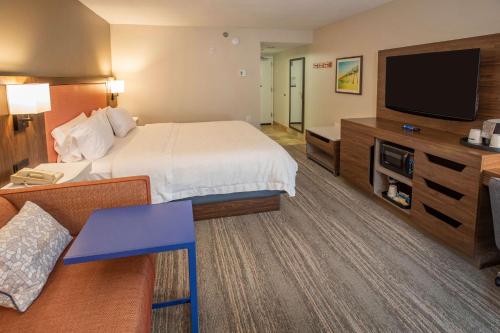 Habitación de hotel con cama y TV de pantalla plana. en Hampton Inn Pensacola-Airport en Pensacola